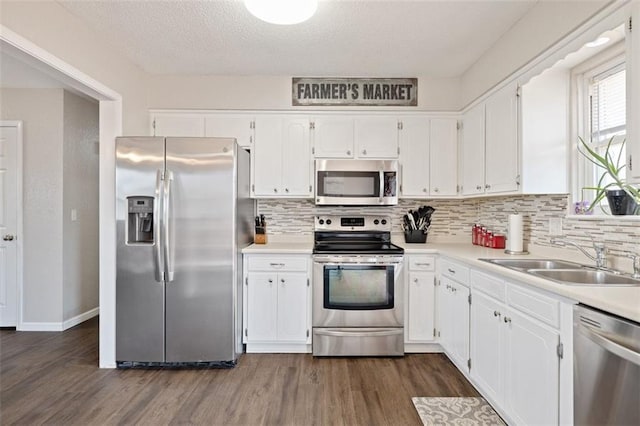 kitchen with white cabinetry, stainless steel appliances, dark hardwood / wood-style floors, and sink