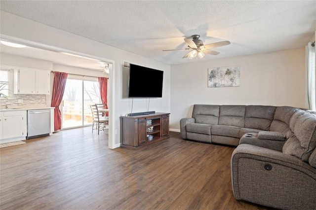 living room featuring hardwood / wood-style floors, a textured ceiling, sink, and ceiling fan