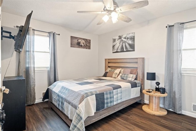 bedroom featuring dark wood-type flooring, ceiling fan, and multiple windows