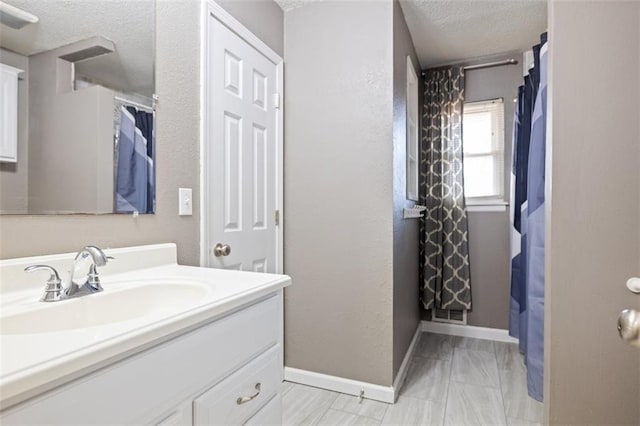 bathroom with vanity, a textured ceiling, and walk in shower