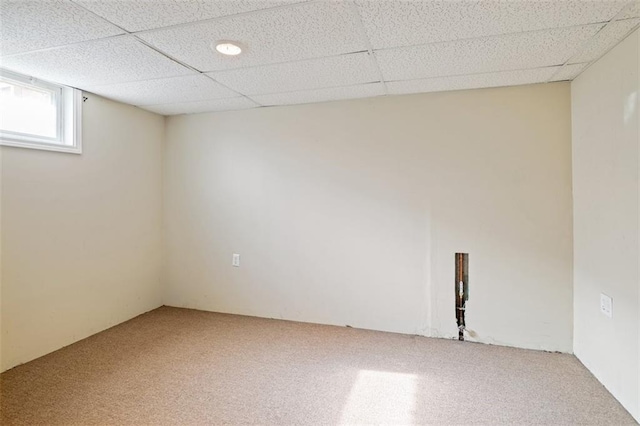 basement with carpet flooring and a paneled ceiling