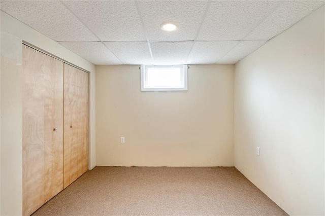 interior space with a closet, carpet, and a drop ceiling