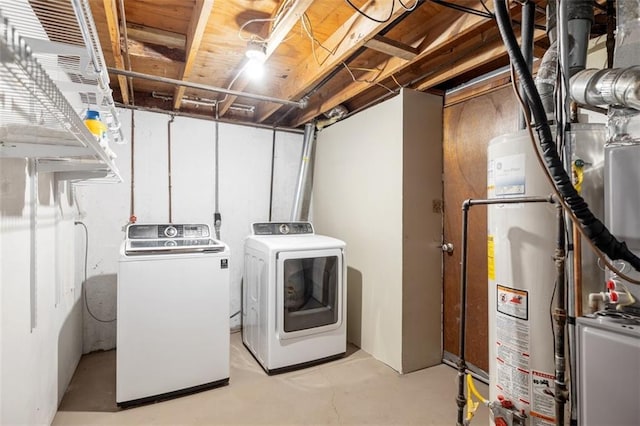 clothes washing area featuring water heater and washing machine and dryer