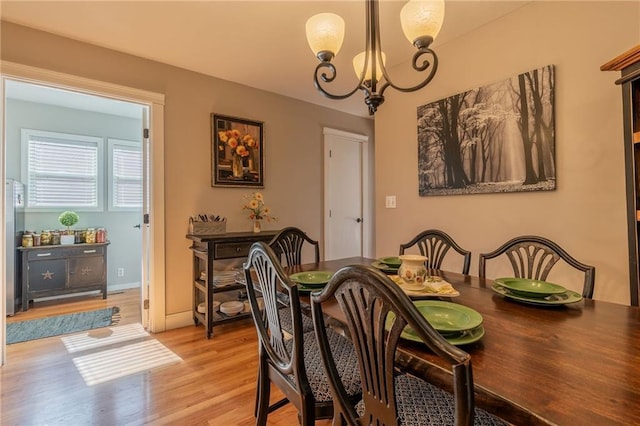 dining area featuring light hardwood / wood-style floors and a notable chandelier