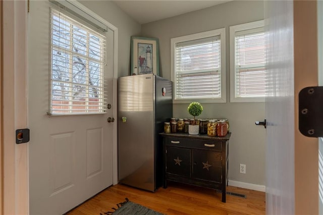 doorway with a wealth of natural light and light hardwood / wood-style floors