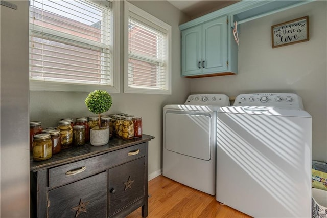 washroom featuring light hardwood / wood-style flooring, cabinets, and washing machine and clothes dryer