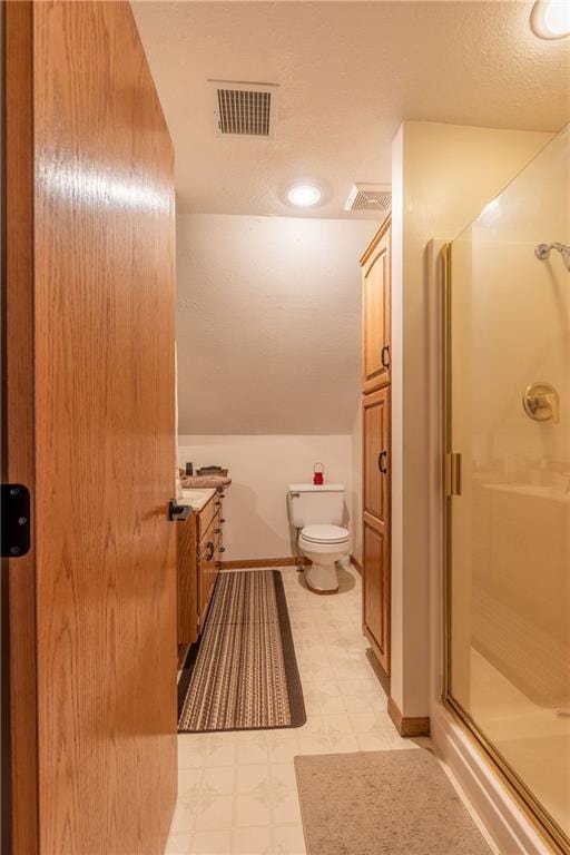 bathroom featuring lofted ceiling, toilet, an enclosed shower, a textured ceiling, and vanity