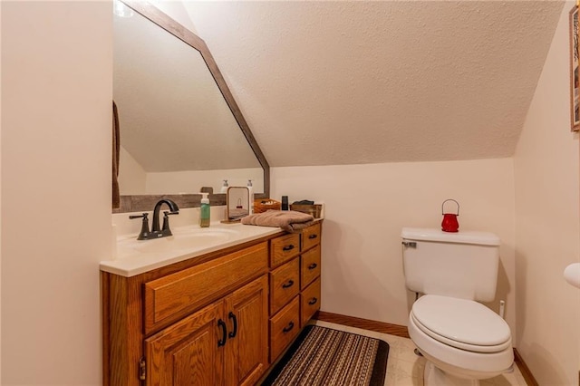 bathroom with vanity, lofted ceiling, a textured ceiling, and toilet