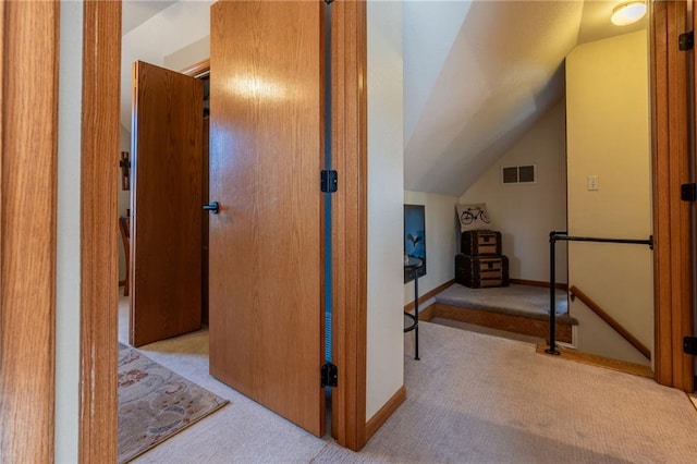 corridor with light carpet and lofted ceiling