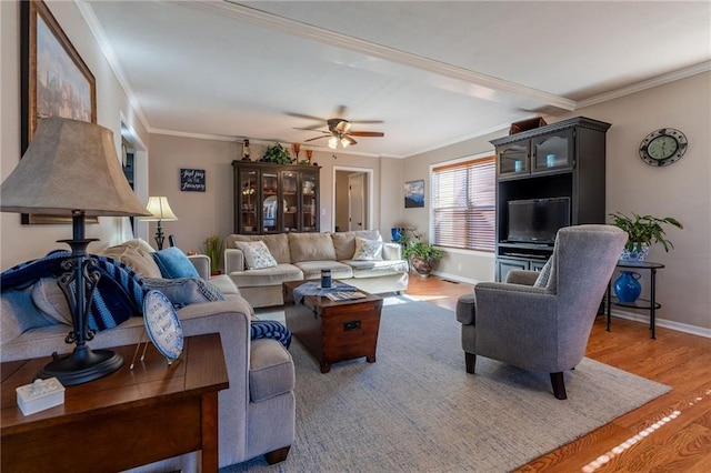 living room with hardwood / wood-style flooring, ornamental molding, and ceiling fan