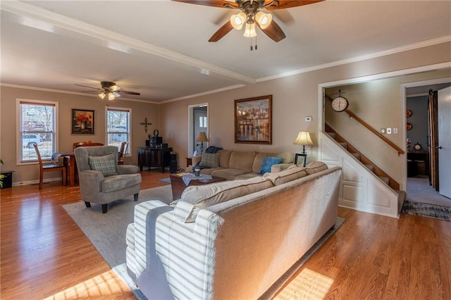 living room featuring ceiling fan, ornamental molding, and light hardwood / wood-style flooring