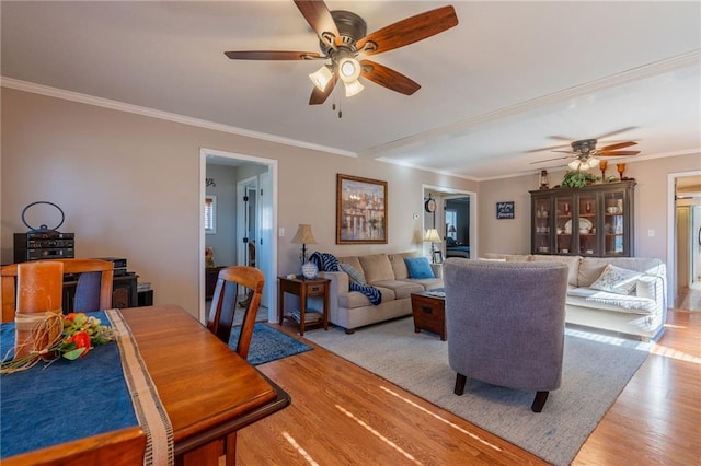 living room featuring crown molding, light hardwood / wood-style flooring, and ceiling fan