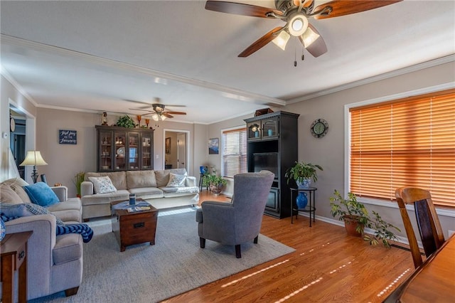 living room featuring hardwood / wood-style flooring, ornamental molding, and ceiling fan