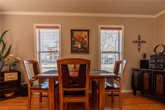 dining room featuring crown molding and light hardwood / wood-style flooring