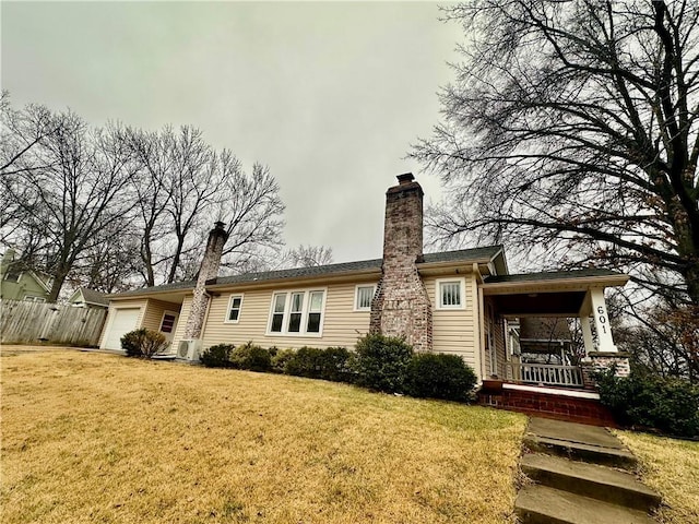 back of house with a yard, a garage, and a porch