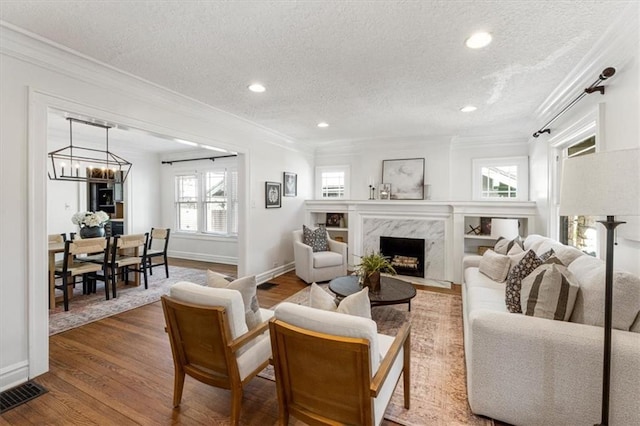 living room with visible vents, wood finished floors, and crown molding