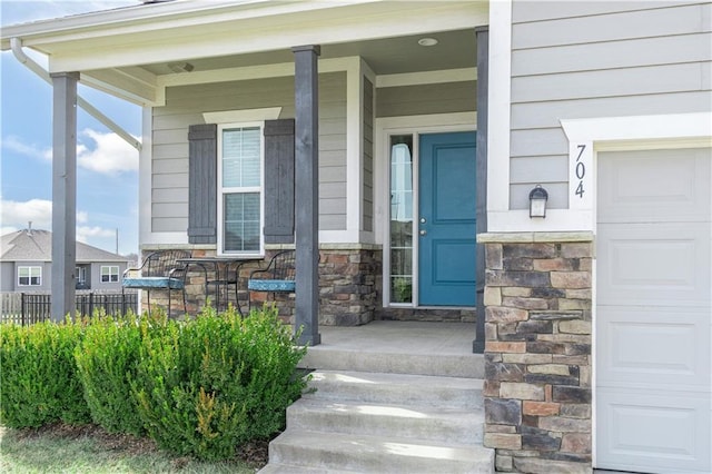 entrance to property featuring a garage and a porch