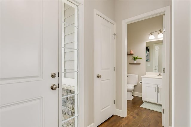 bathroom with wood-type flooring, vanity, and toilet