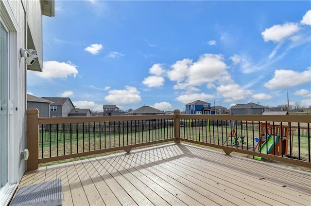 wooden terrace with a lawn and a playground