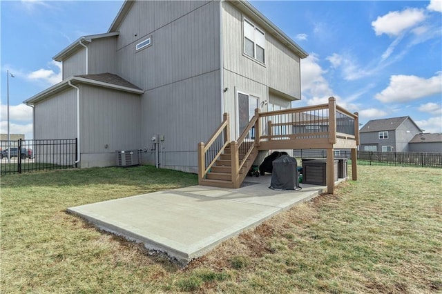 rear view of house featuring a wooden deck, a yard, a patio, and cooling unit