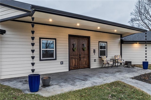 view of exterior entry with a patio area