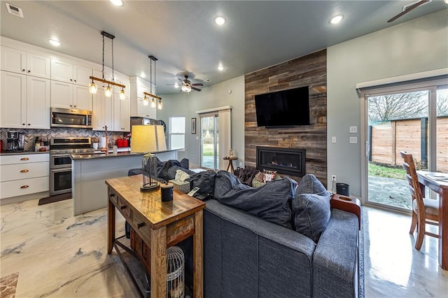 living room featuring a fireplace and ceiling fan