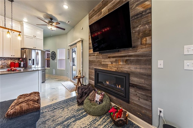 living room with a fireplace and ceiling fan