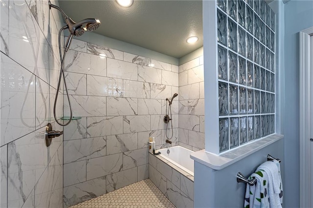 bathroom with a tub, a textured ceiling, and a tile shower