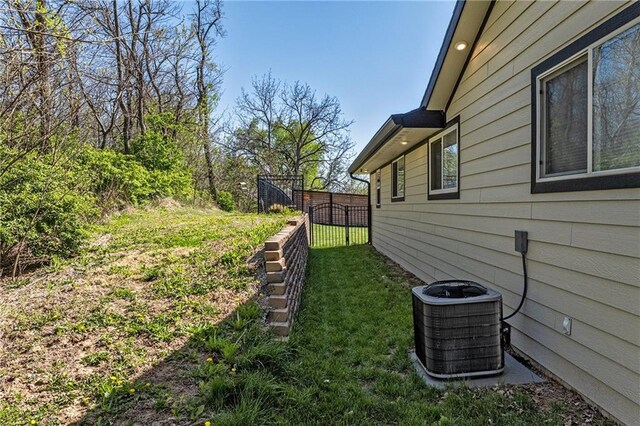view of yard with central AC unit and fence
