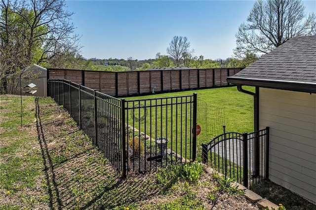 view of yard with a fenced backyard, an outdoor structure, and a shed