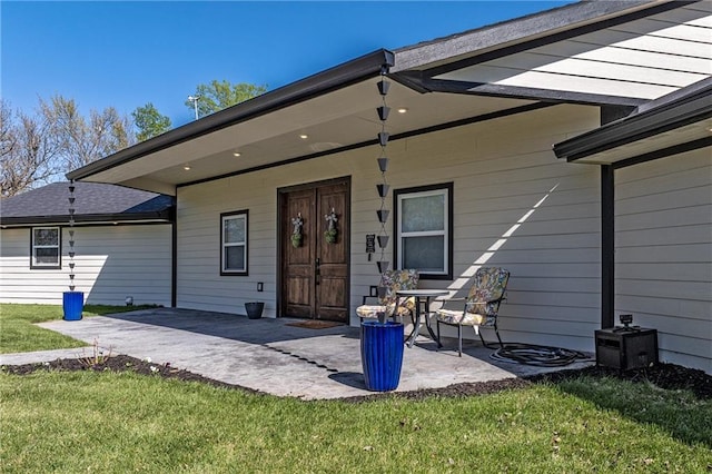 rear view of property with a lawn and a patio