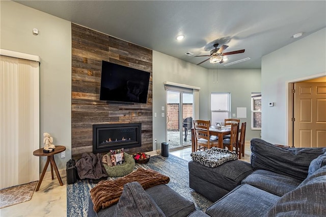 living room with baseboards, a ceiling fan, visible vents, and a tiled fireplace