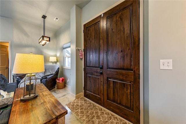 foyer entrance featuring visible vents and baseboards