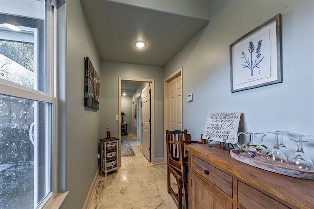 hallway with recessed lighting, marble finish floor, and baseboards