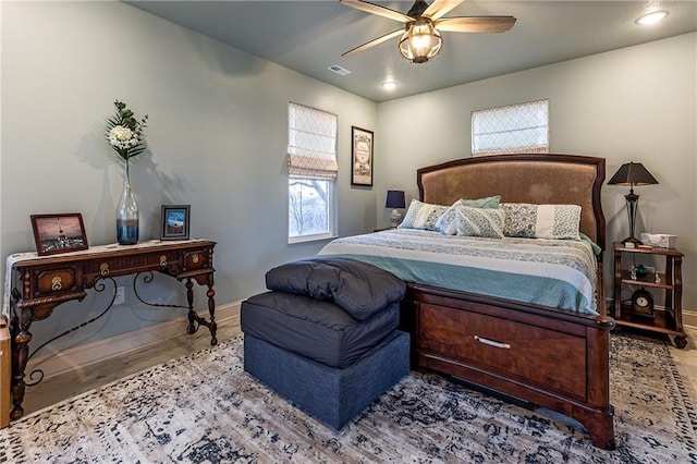 bedroom featuring visible vents, baseboards, and multiple windows