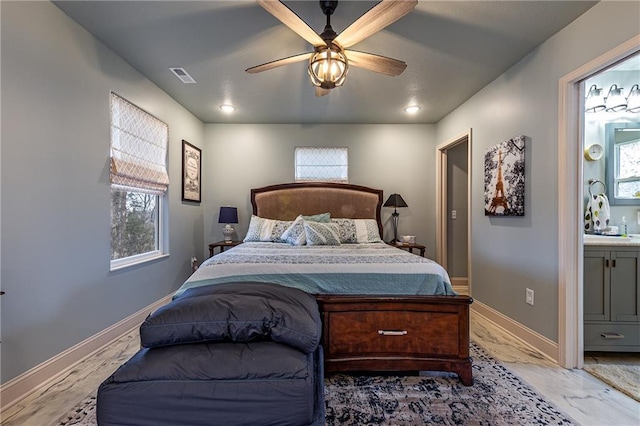 bedroom with visible vents, baseboards, multiple windows, and connected bathroom