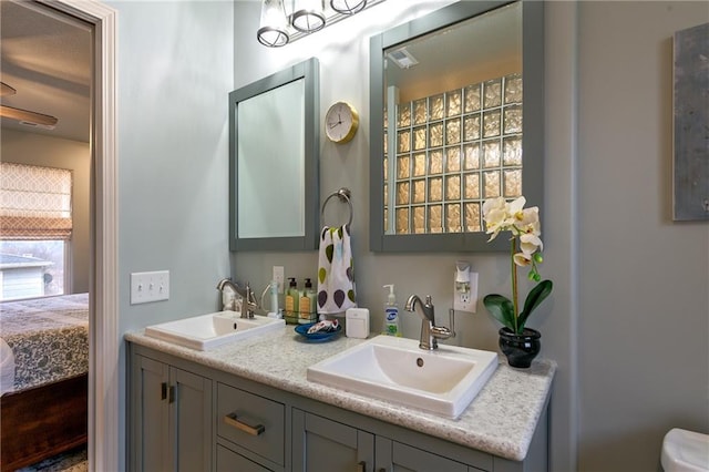 ensuite bathroom with toilet, a sink, double vanity, and ensuite bathroom