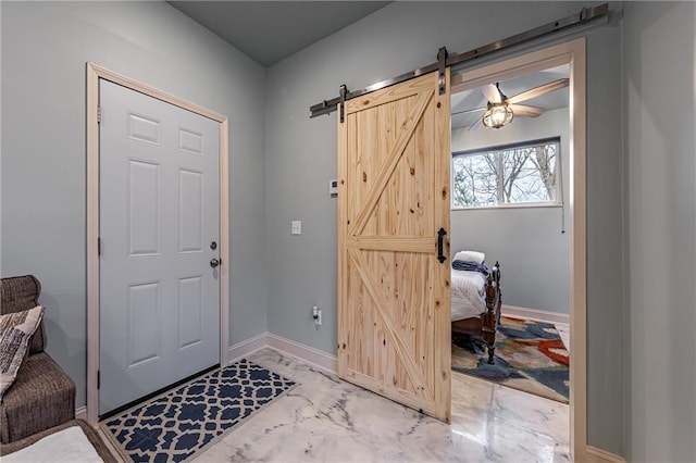 foyer entrance with baseboards, marble finish floor, and a barn door