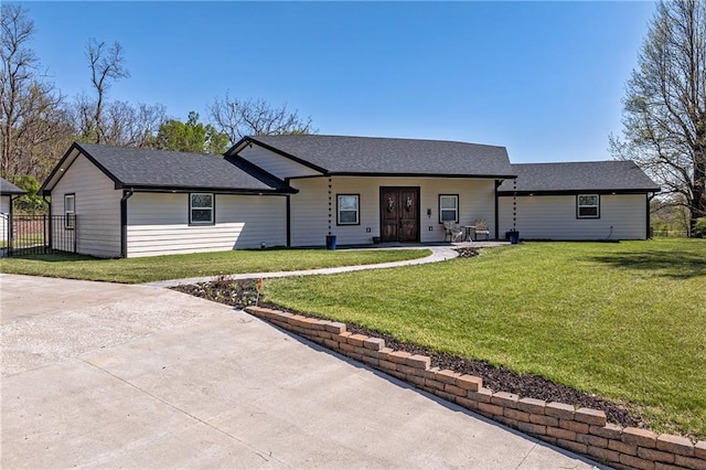 single story home with fence, roof with shingles, a front yard, and a patio
