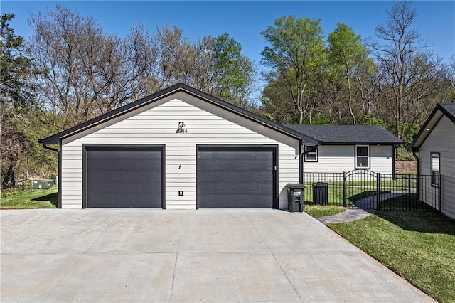 view of front of house with an attached garage, concrete driveway, a front yard, and fence
