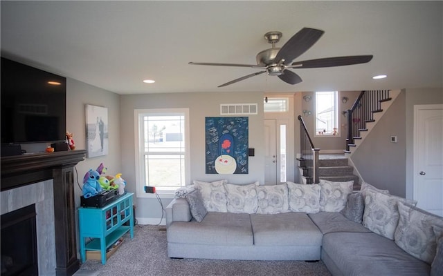 living room featuring carpet floors, a healthy amount of sunlight, and ceiling fan