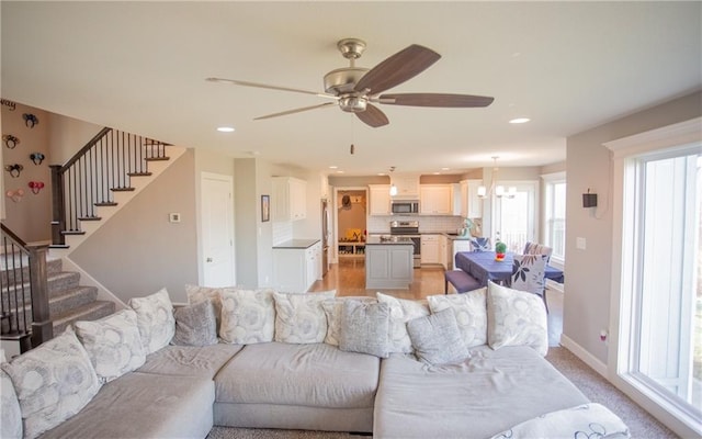 living room featuring ceiling fan with notable chandelier