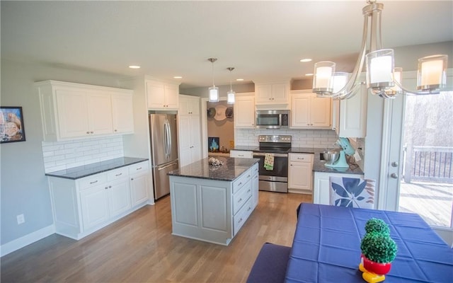 kitchen featuring white cabinetry, appliances with stainless steel finishes, a center island, and pendant lighting