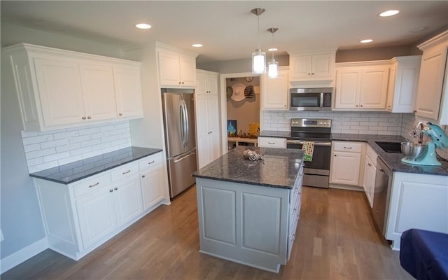 kitchen with white cabinetry, hanging light fixtures, and stainless steel appliances