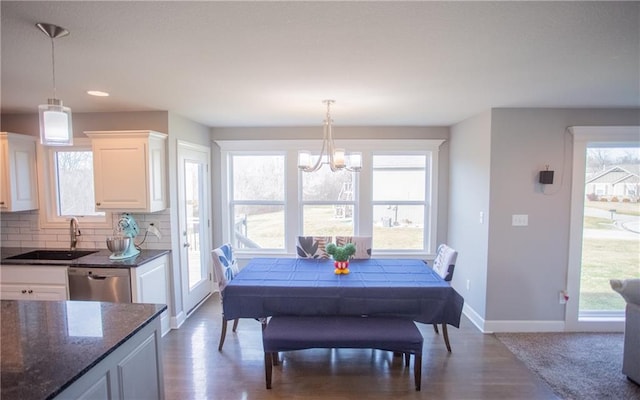 dining area with dark wood-type flooring, plenty of natural light, and sink