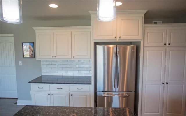 kitchen with white cabinetry, pendant lighting, stainless steel fridge, and decorative backsplash