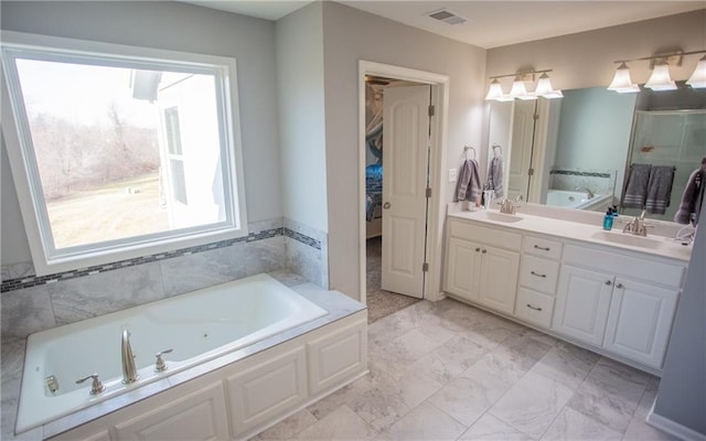 bathroom featuring vanity and separate shower and tub