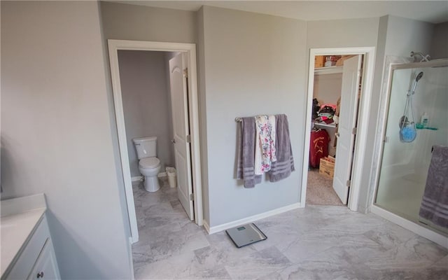 bathroom featuring vanity, toilet, and an enclosed shower