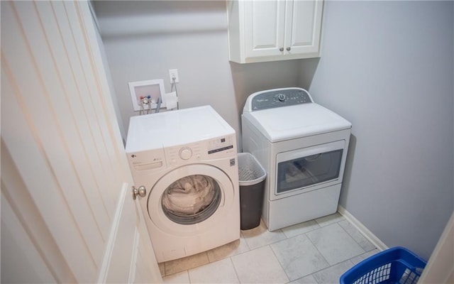 washroom with cabinets and washing machine and clothes dryer