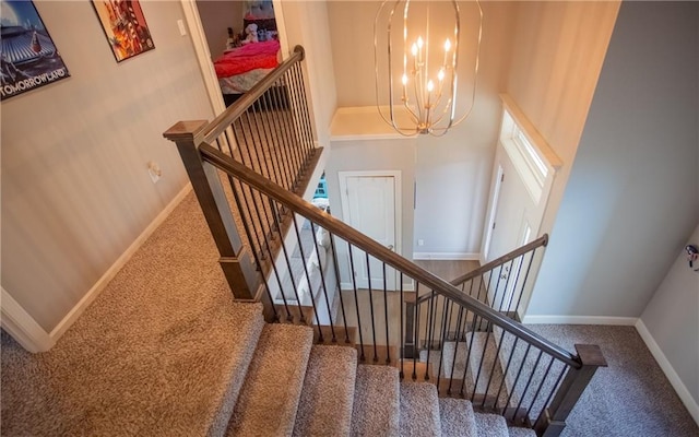 staircase with carpet, a towering ceiling, and a chandelier